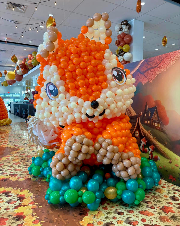Balloon sculpture of a squirrel in an indoor setting with a colorful background