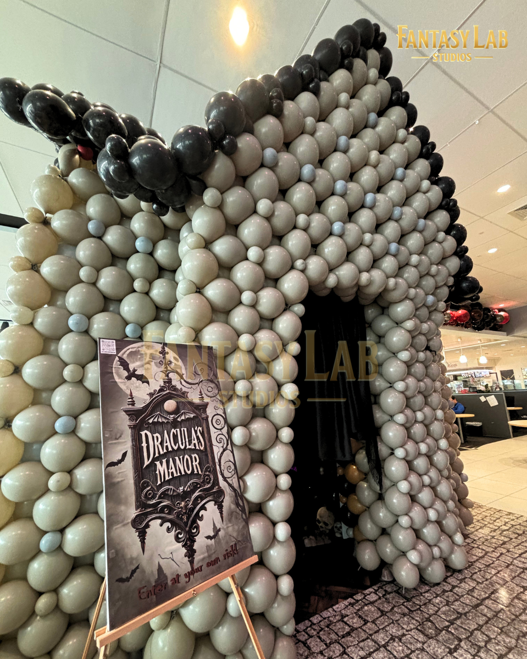 Balloon-built manor entrance with gothic archway and Dracula’s Manor sign.