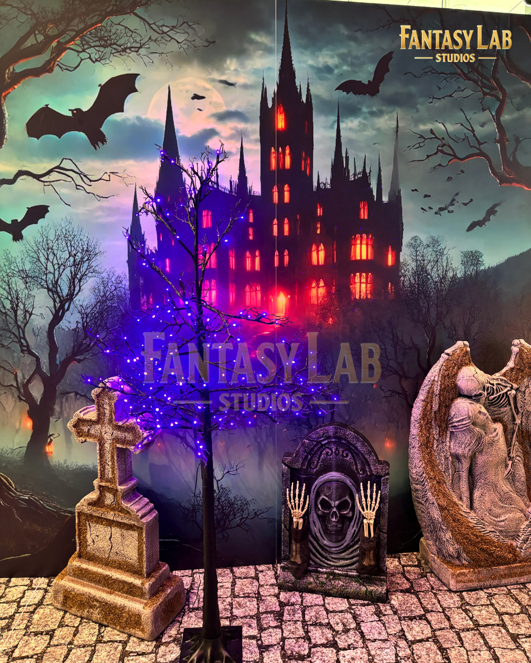 Gothic castle backdrop with lit tree, gravestones, and cobblestone floor graphic.