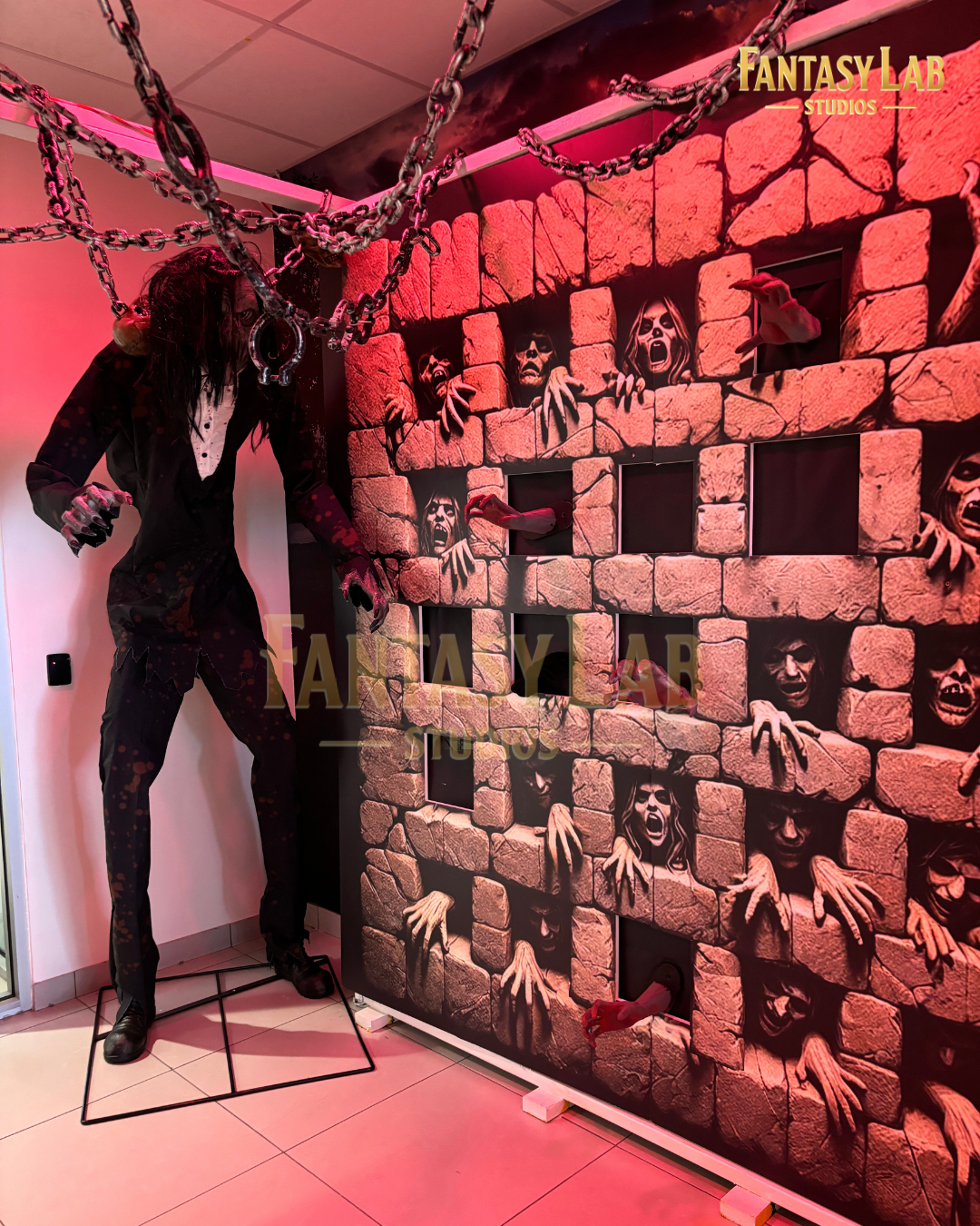 Red-lit wall-of-hands scenic with chains and a towering figure.